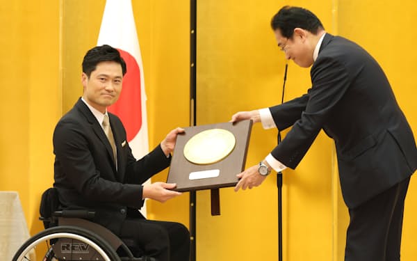 岸田首相から国民栄誉賞の記念の盾を受け取る国枝慎吾さん(17日、首相官邸)