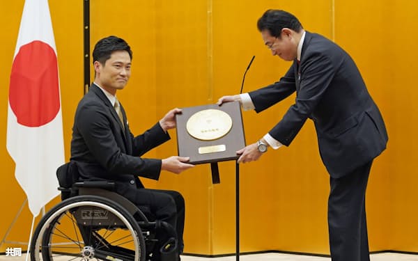 国民栄誉賞表彰式で、岸田首相(右)から盾を受け取る元車いすテニス男子の国枝慎吾さん=17日午後、首相官邸
