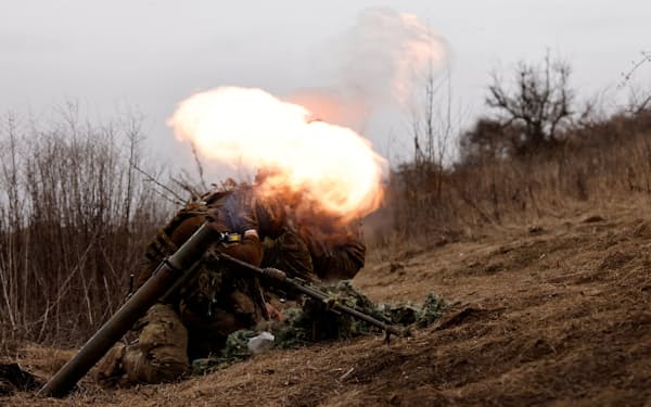 ロシア軍が攻撃を仕掛けるなか、バフムト付近の前線陣地で、砲弾で応戦するウクライナ軍の兵士（16日、ウクライナ東部ドネツク州）=ロイター