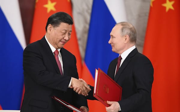 21日、モスクワのクレムリンで共同声明に署名し、握手する中国の習近平国家主席㊧とロシアのプーチン大統領＝AP