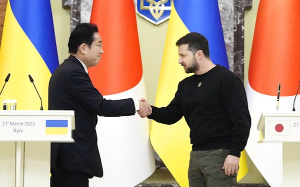 記者会見を終え、ウクライナのゼレンスキー大統領㊨と握手する岸田首相（21日、キーウ）＝共同