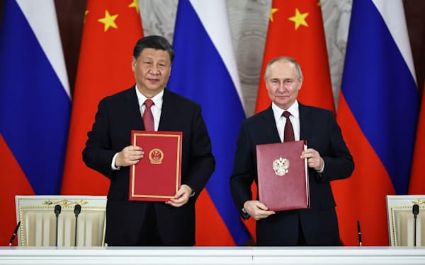 21日、モスクワで署名式に出席したロシアのプーチン大統領（右）と中国の習近平国家主席（ロイター=共同）