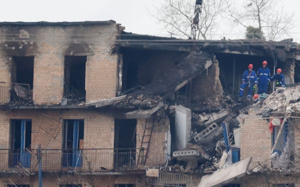 22日、ロシアのドローン攻撃で破壊された建物で行われた救助活動（キーウ州）=ロイター