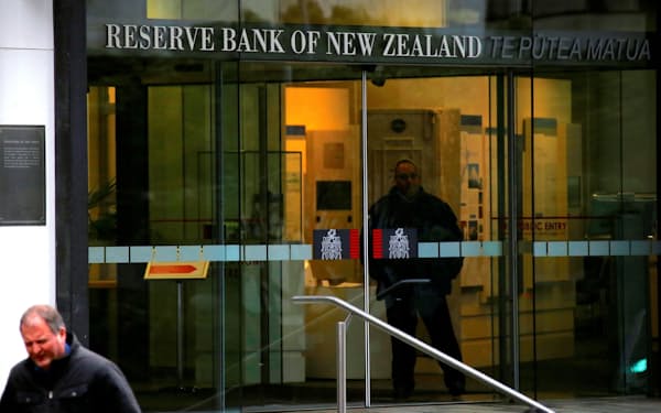 FILE PHOTO: Pedestrians walk past as a security guard stands in the main entrance to the Reserve Bank of New Zealand located in central Wellington, New Zealand, July 3, 2017. Picture taken July 3, 2017.   REUTERS/David Gray/File Photo