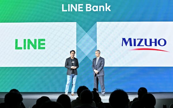 LINE Bankでの提携を発表するLINEの出沢剛社長(左)とみずほフィナンシャルグループの岡部俊胤副社長(2018年)