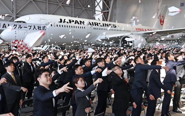 JALグループの入社式で紙飛行機を飛ばす新入社員（3日、東京都大田区）