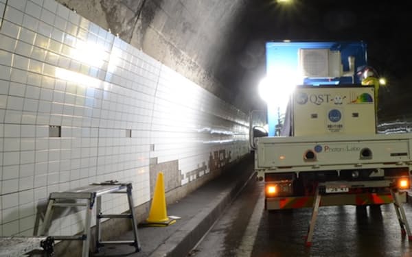 車両に搭載した装置からレーザーでトンネルのタイルを点検する（建設技術研究所提供）