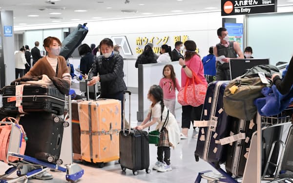 海外から入国した人たちで混雑する成田空港の国際線到着ロビー