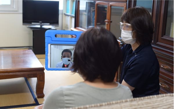 看護師がタブレットを操作し、大井田病院の医師がオンラインで診療する実証事業