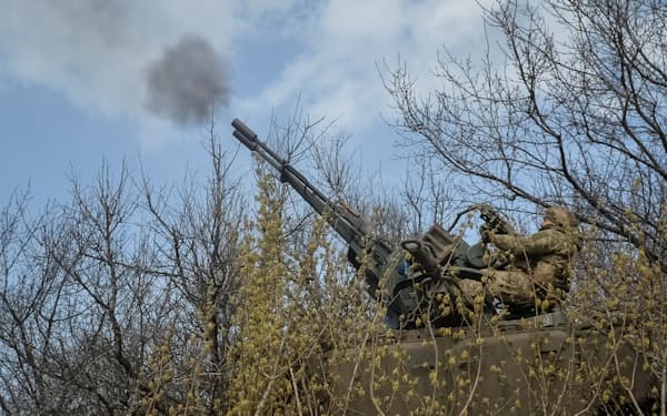 ウクライナは激戦地で踏みとどまり反攻の準備を急いできた（７日、バフムト周辺で対空砲を撃つウクライナ軍の兵士）＝ロイター