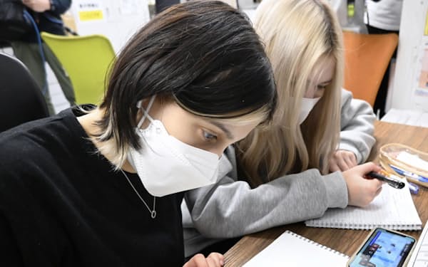 オンライン授業で日本語を学ぶ女性（2月、都内）＝共同