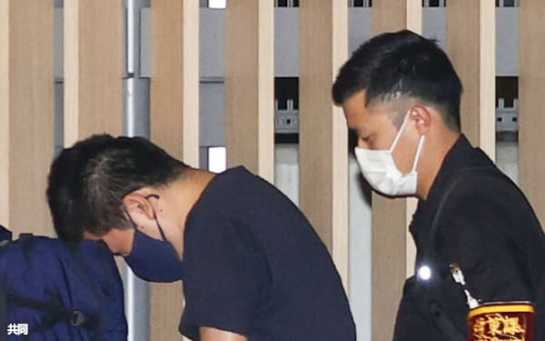 カンボジアを拠点とした特殊詐欺事件で逮捕され、羽田空港に到着した容疑者㊧(11日午後11時)=共同