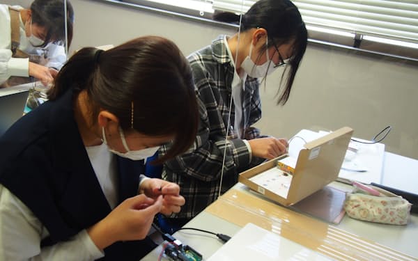 電子回路を組み立て、LEDを光らせる作業に熱中する(奈良市の奈良女子大学)