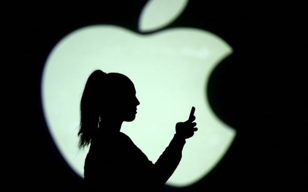 FILE PHOTO: Silhouette of a mobile user seen next to a screen projection of the Apple logo in this picture illustration taken March 28, 2018.  REUTERS/Dado Ruvic/Illustration/File Photo