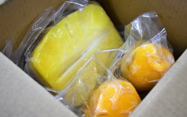 パイナップルやマンゴーは色付きや形が悪くても、皮をむいて冷凍。商品として出荷する