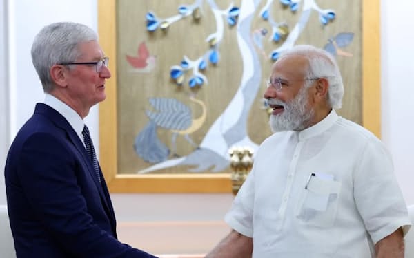 握手をするインドのモディ首相㊨とアップルのクックＣＥＯ（１９日）＝クック氏のツイッター投稿から