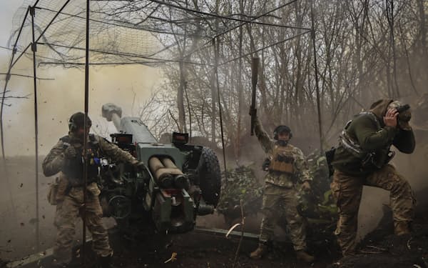 19日、東部ドネツク州のバフムト近郊でロシア軍を砲撃するウクライナ兵＝AP