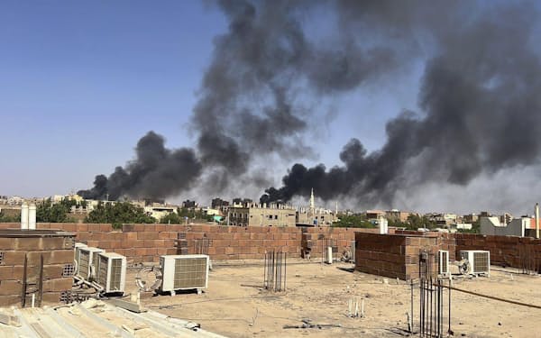 21日、煙の立ちのぼるスーダン首都ハルツーム＝Maheen S提供・AP