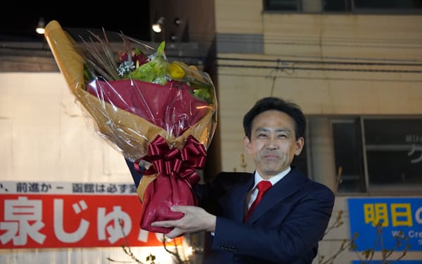 函館市長選で当選を決め、花束を受け取る大泉氏（２３日、函館市）