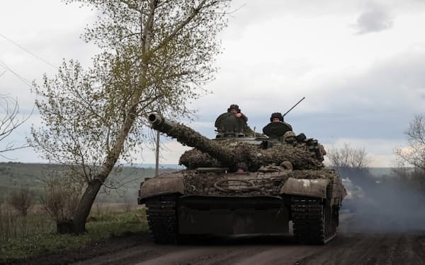 ウクライナ東部ドネツク州の前線付近を戦車で移動するウクライナ軍の兵士ら＝ロイター