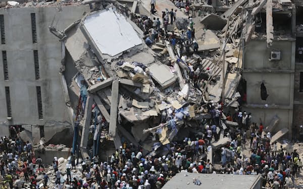 崩壊したビル「ラナプラザ」から生存者を救助しようとする人々（２０１３年４月２４日、サバール）＝ロイター