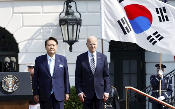 米ホワイトハウスでセレモニーに臨む韓国の尹錫悦大統領㊧とバイデン大統領（26日）＝ロイター