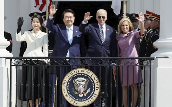 米ホワイトハウスで手を振る韓国の尹錫悦大統領夫妻（左）とバイデン大統領夫妻（26日）＝ロイター