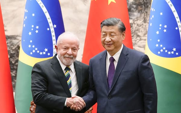 調印式でブラジルのルラ大統領（左）と握手をする中国の習近平国家主席＝14日、北京の人民大会堂（共同）