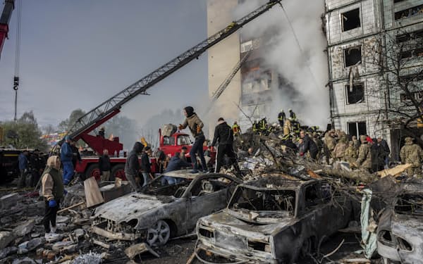 28日、ウクライナ中部のウマニでロシアのミサイル攻撃により崩壊した建物で救出活動が続く＝AP
