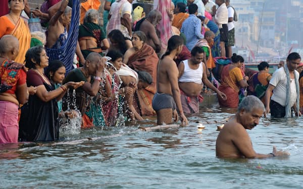 早朝のガンジス川で沐浴をする人々。ヒンズー教徒は一生に一度は、この地で母なる大河に身を浸したいと願う（ヴァーラーナシー）
