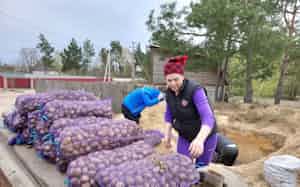 ポズナニ村ではベラルーシ側にキノコ採りなどに出かけることはなくなった(4月20日、同村でジャガイモを運ぶ女性)