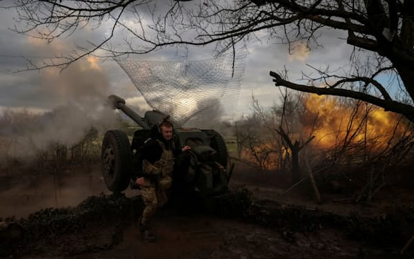 4月23日、ウクライナ東部のバフムト近郊でロシア軍を砲撃するウクライナ軍兵士＝ロイター