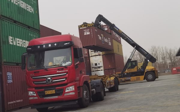 天津港で輸出用コンテナを運ぶクレーン車