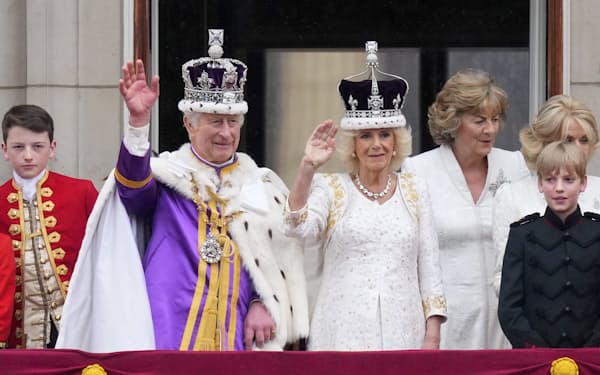 戴冠式を終えた国王夫妻はロイヤルファミリーとともにバッキンガム宮殿のバルコニーから手を振った（６日）＝ＡＰ