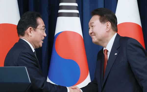 共同記者会見を終え、韓国の尹錫悦大統領（右）と握手する岸田首相（7日、ソウルの大統領府）＝代表撮影・共同