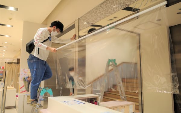 名鉄百貨店本店で開店前に飛沫感染対策のビニールシートを撤去(8日、名古屋市)