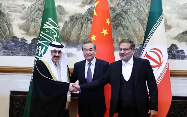 3月10日、サウジアラビアとイランの当局者と握手する中国の王毅・共産党政治局員（中央）＝ロイター