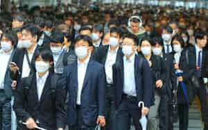 多くの人はマスクを着けて通勤している(8日、JR品川駅前)
