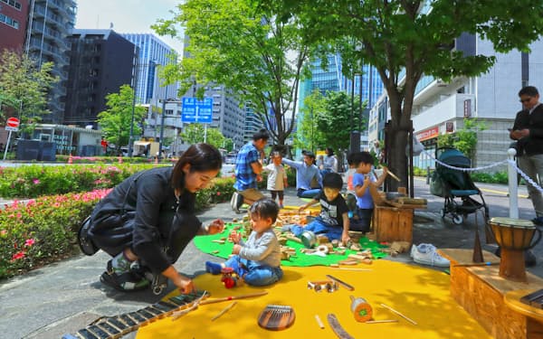 広い歩道に作られた遊び場は子どもたちでにぎわう（４月、東京都港区の新虎通り）