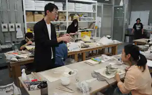 共通工房の陶磁成形室で、学生の制作をサポートする技術専門員の今西氏(左手前) 共通工房の陶磁成形室で、学生の制作をサポートする技術専門員の今西氏(左手前)