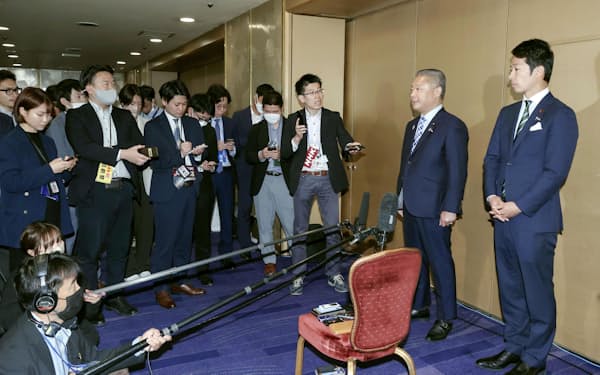 日本維新の会の臨時党大会を終え、報道陣の取材に応じる馬場代表（右から2人目）（14日午前、大阪市）＝共同