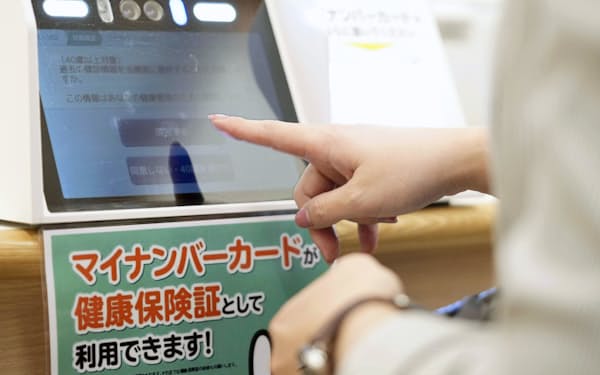 健康保険証とマイナンバーカードを一つにした「マイナ保険証」を利用するための読み取り機（2021年10月、東京都内の病院）＝共同