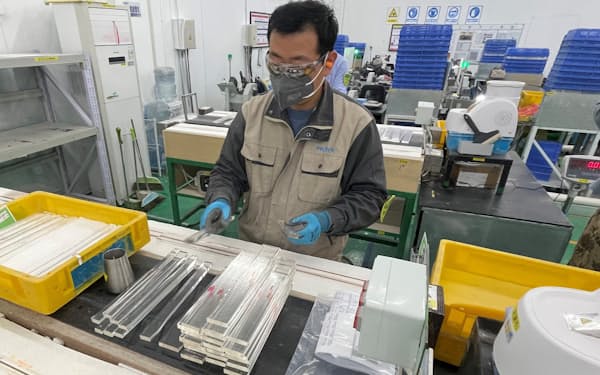 光学ガラス材料を切断するHOYA中国拠点の作業員(中国・山東省威海市)