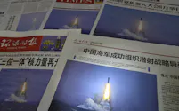 中国軍が潜水艦発射弾道ミサイル(SLBM)を発射した写真を掲載した7日付の中国各紙=共同