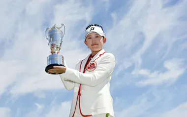 通算22アンダーでツアー初優勝を果たし、トロフィーを手にする加藤麗奈(26日、ザ・クイーンズヒルGC)=共同