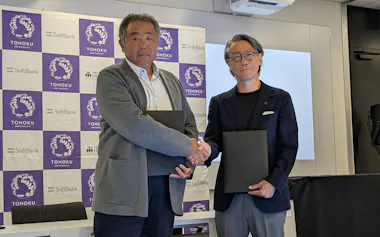 握手を交わすソフトバンクの丹波常務執行役員㊧と東北大学災害科学国際研究所の越村所長(27日、東京都港区)
