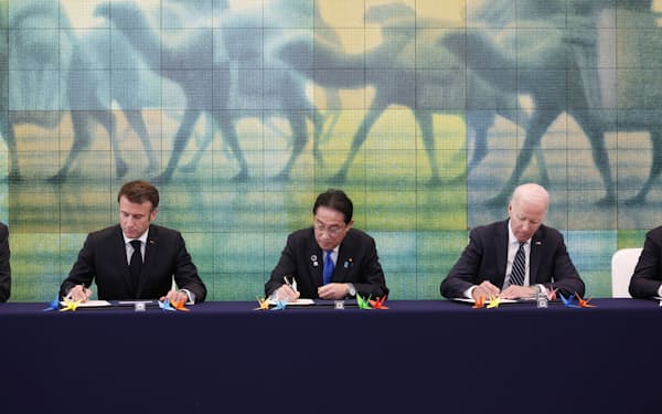 原爆資料館で記帳する(左から)フランスのマクロン大統領、岸田首相、バイデン米大統領(19日、広島市)