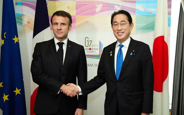 首脳会談前、フランスのマクロン大統領（左）と握手を交わす岸田首相(19日午前、広島市南区）