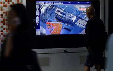 熊本での地震に関する報道を見る人(28日、東京都)=ロイター