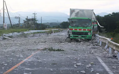 地震から一夜明け、爆発時のがれきが散乱するイオンモール熊本周辺の道路(29日午前、熊本県嘉島町)